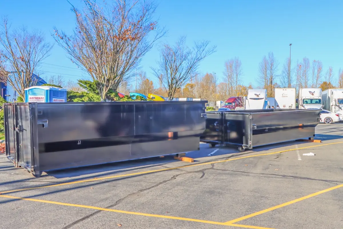 Professional dumpster rental service with roll-off container on residential driveway in Mission